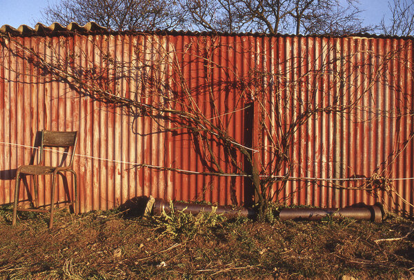 La palissade rouge à l'arrière du jardin de mon Grand père Dziadek, par Jacques Mielcarek Photographie minimaliste d'une palissade rouge illustrant la démarche artistique