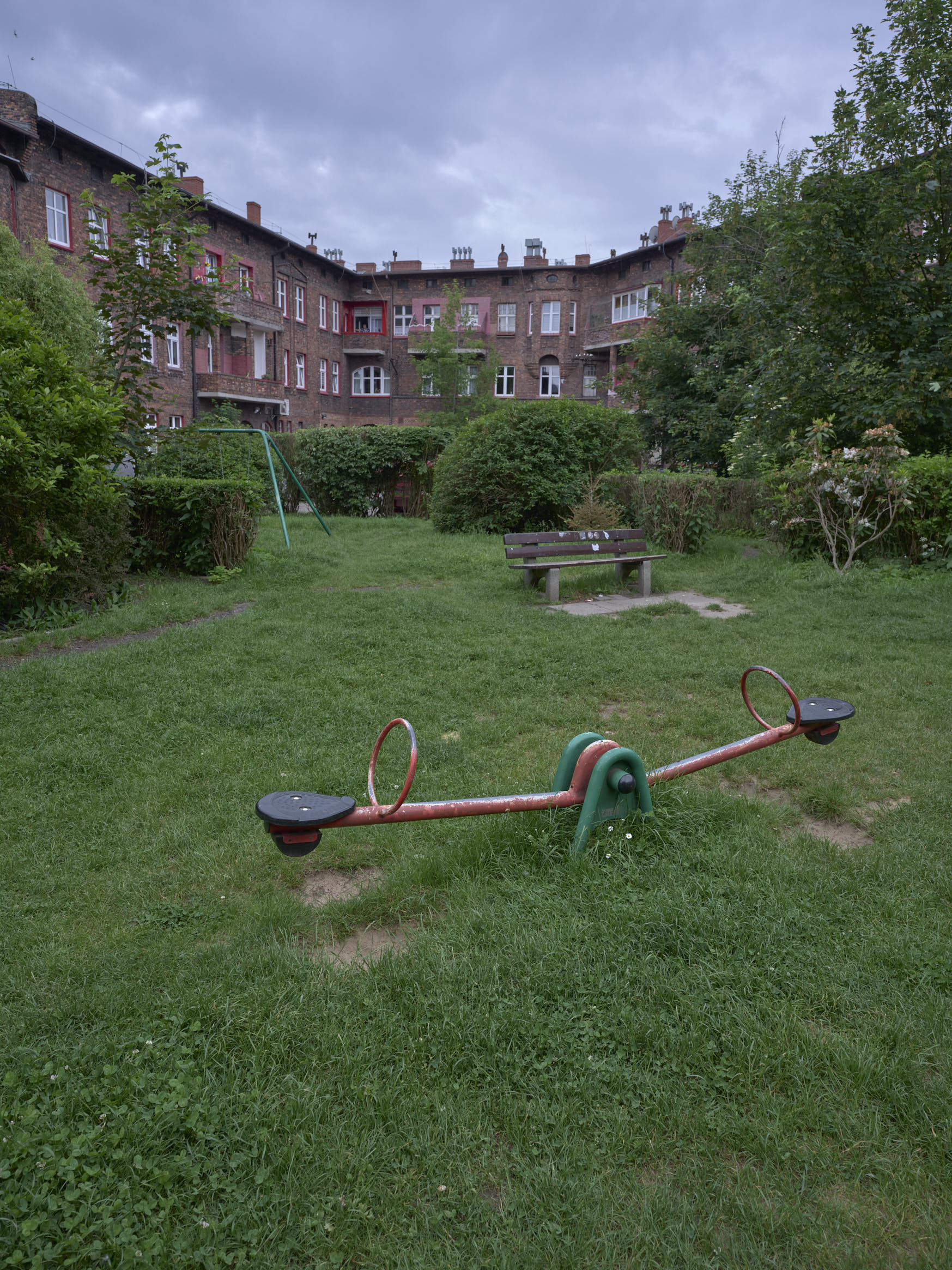 Un jardin d'enfants sur fond de cité ouvrière enbriques rouges, et avec des cheminées d'usine en arrière plan