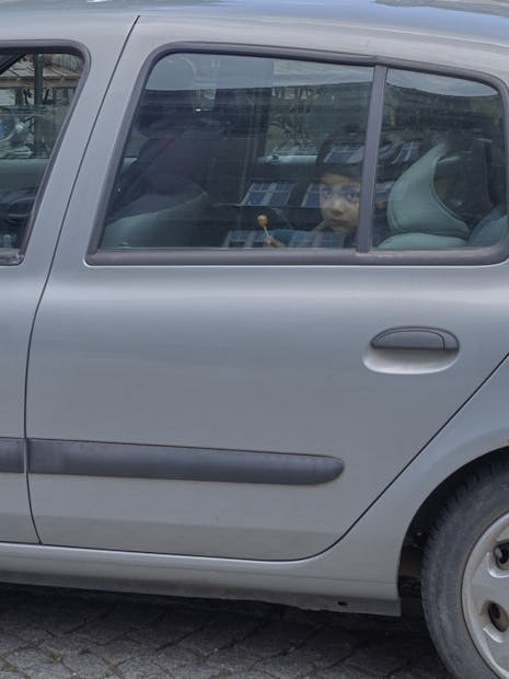 Le regard d'un enfant au travers de la vitre de la voiture