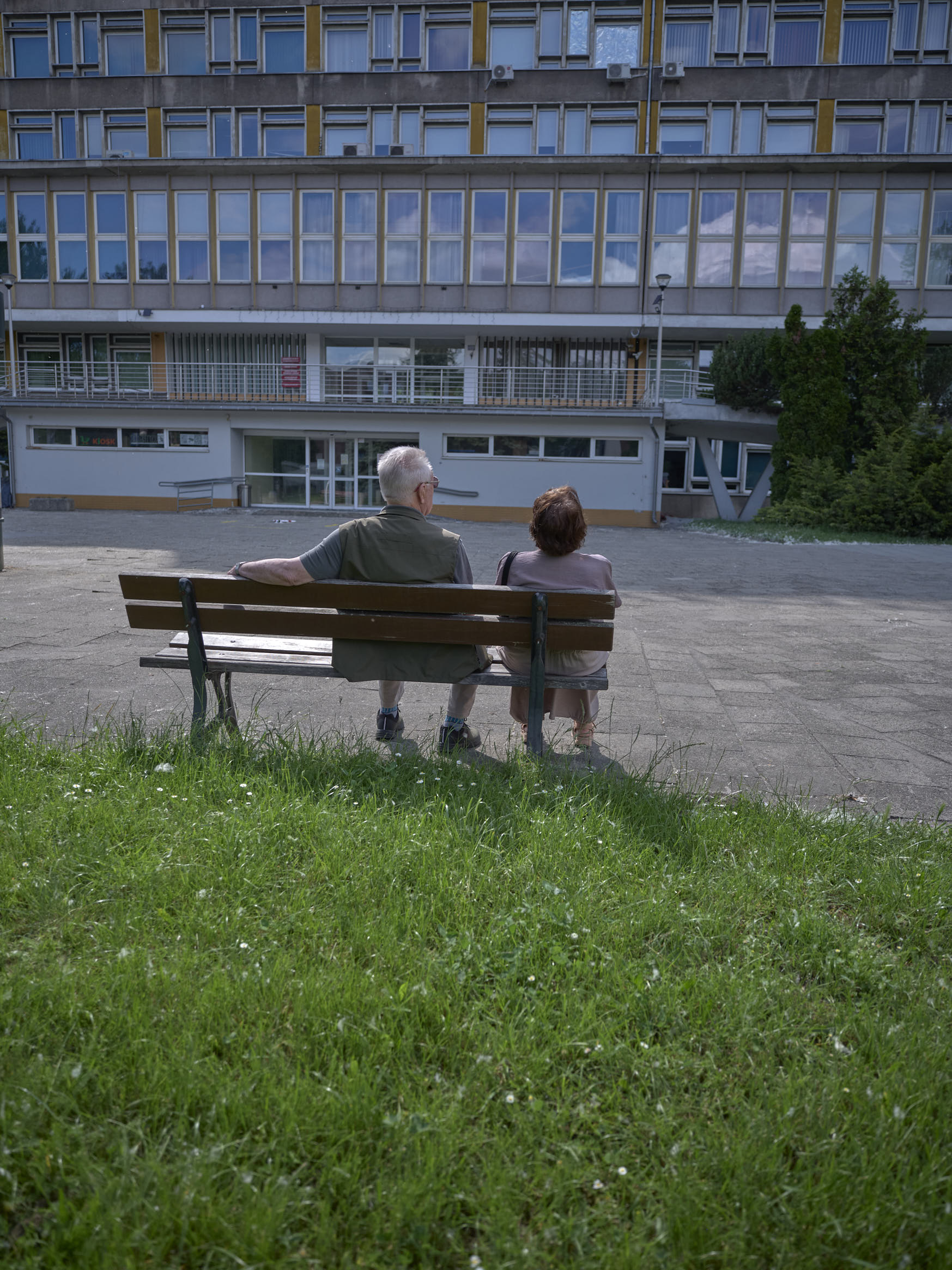 Un couple de retraités regarde un immeuble
